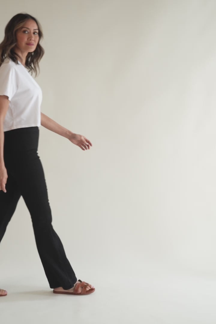 Model walking in black flare pull-on pants in a video, showing how the pants move with the body, emphasizing comfort.
