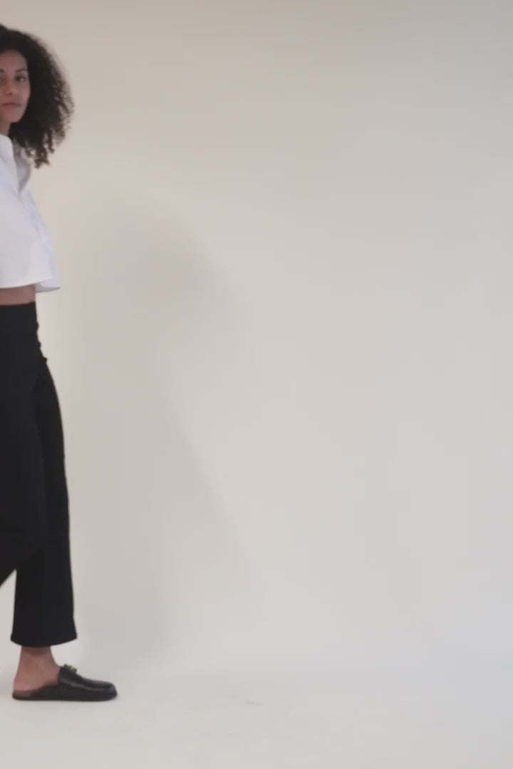 Model walking in cropped black flare pull-on pants in a video, showing comfortable movement and stretchy cropped fit.