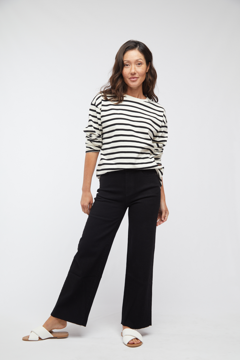 Model wearing black wash wide leg cropped jeans with a striped long-sleeve top, front view showing the casual fit.
