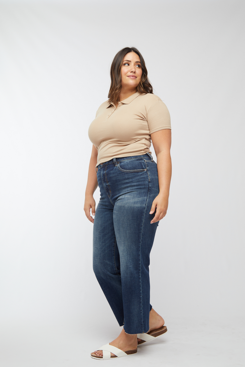 Side view of plus-size model in wide leg cropped jeans, highlighting the dark wash and relaxed fit.