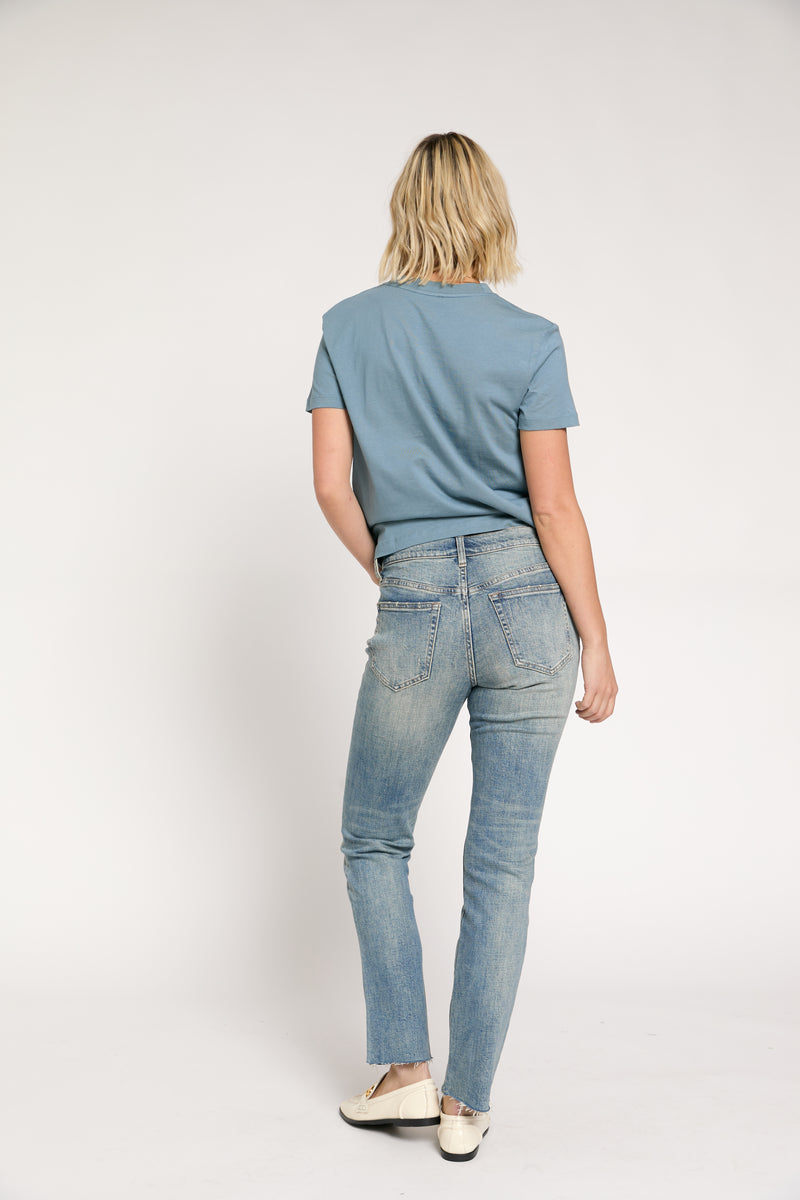 Rear view of model wearing relaxed fit straight leg denim, paired with casual shoes, highlighting the mid-rise design.