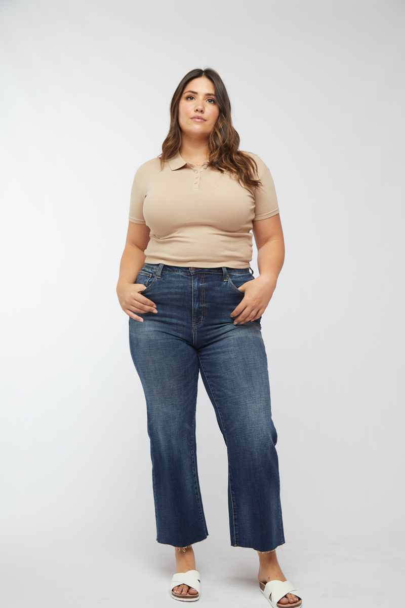 Plus-size model standing confidently in dark wash wide leg jeans, showing off the high waisted fit and casual style.