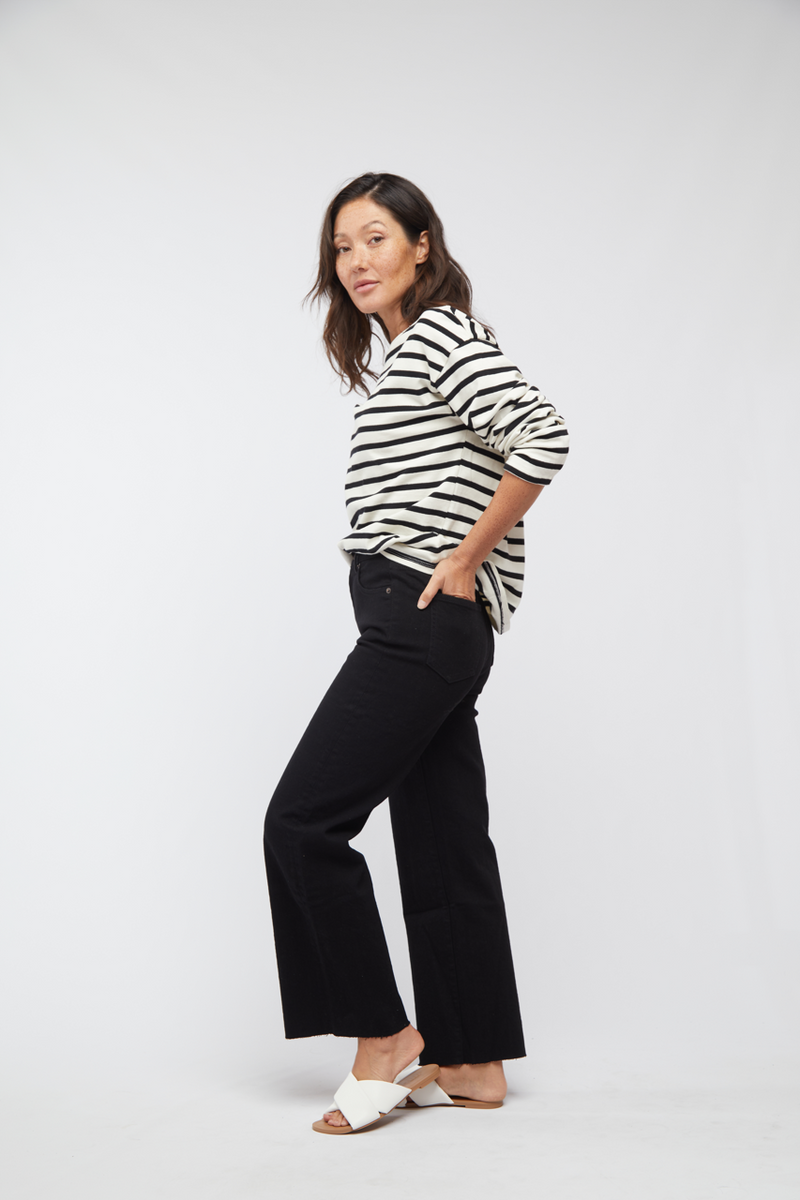 Side view of model in black wash wide leg cropped jeans and striped shirt, displaying the comfortable and modern fit.