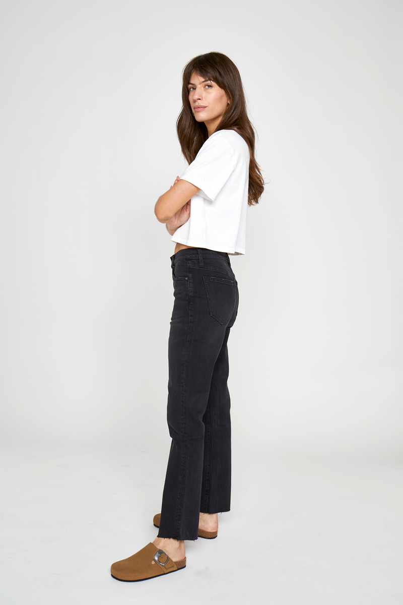 Side view of a model in high-rise tapered-leg jeans, paired with a casual cropped top, showcasing their versatile and stylish appeal.