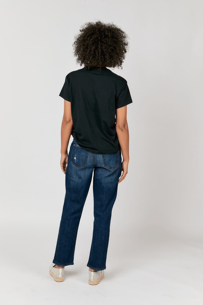 Back view of the model in relaxed fit straight leg denim jeans, highlighting the flattering design with a timeless dark wash.