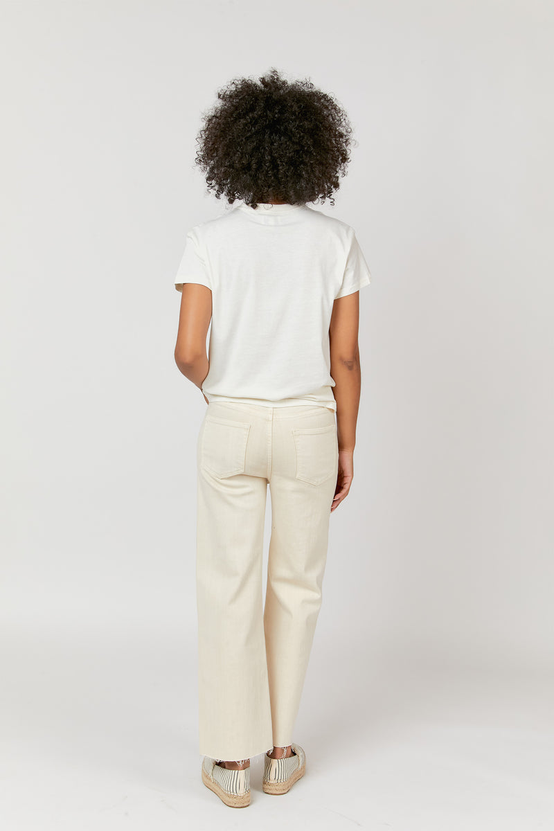 Back view of model in ecru jeans, styled with espadrilles, showcasing the high-rise fit and casual look.