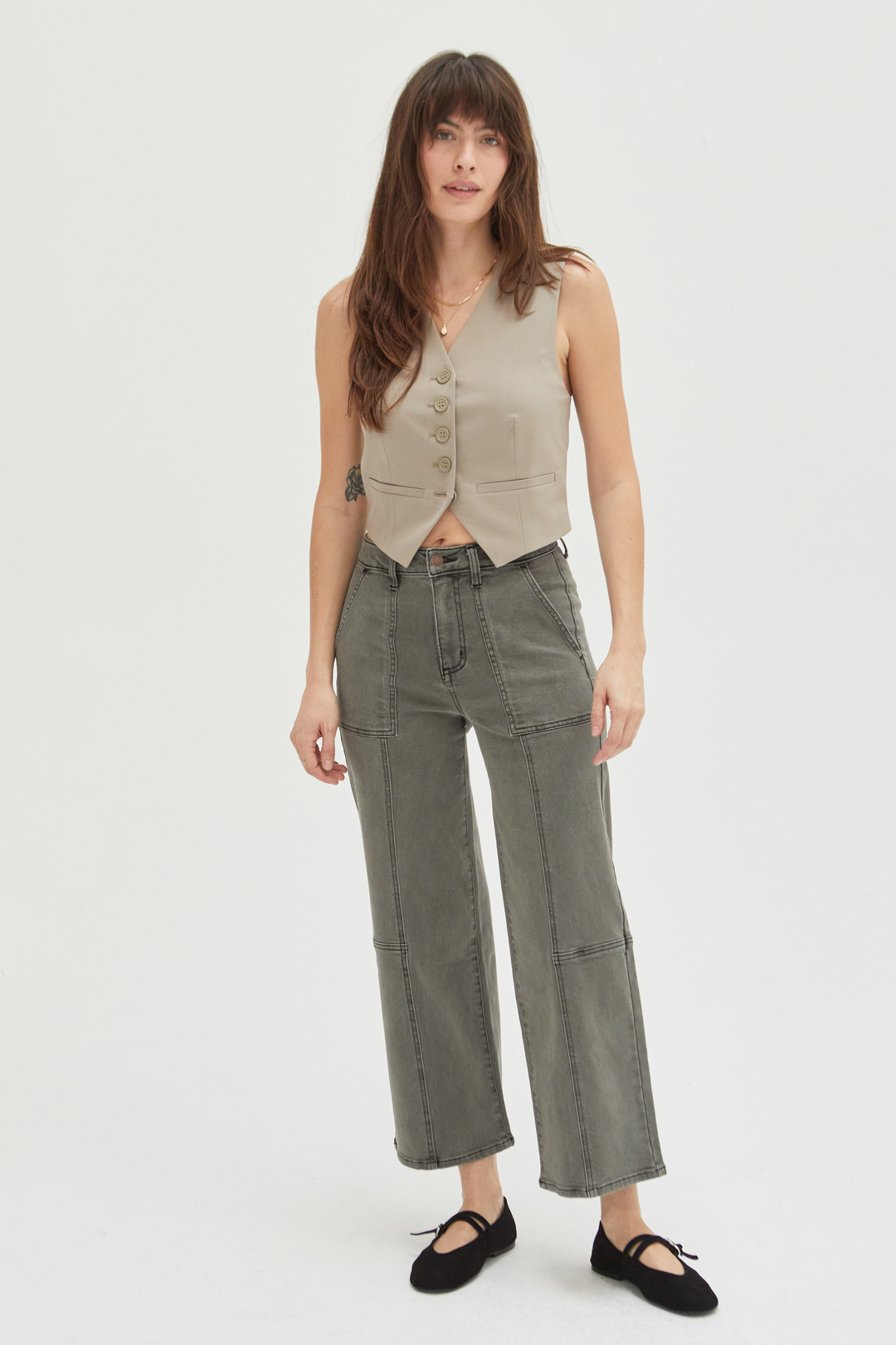 Model wearing wide-leg ankle crop jeans in an olive overdye wash, styled with a beige sleeveless top and black flats, showcasing a relaxed fit and cropped hem.
