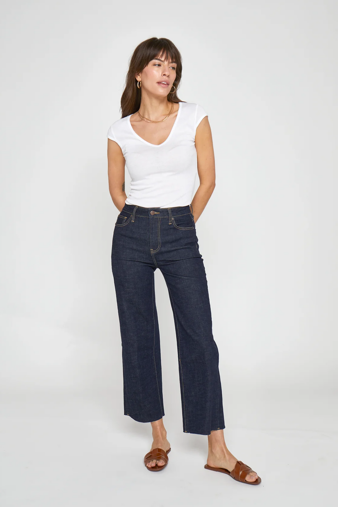 Model wearing women's cropped wide leg jeans in dark wash, paired with a white t-shirt and sandals, front view.