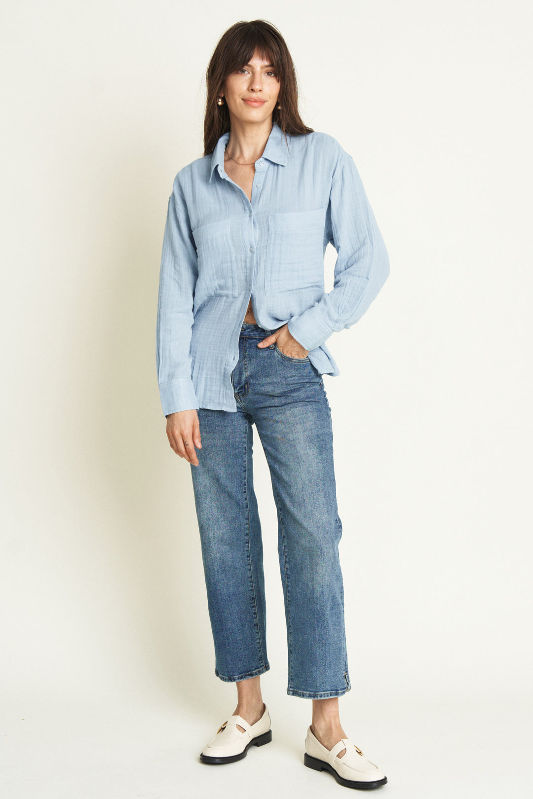 Front view of a model wearing high-rise wide leg crop jeans in medium-wash denim. The jeans feature a relaxed, cropped fit for a modern silhouette.