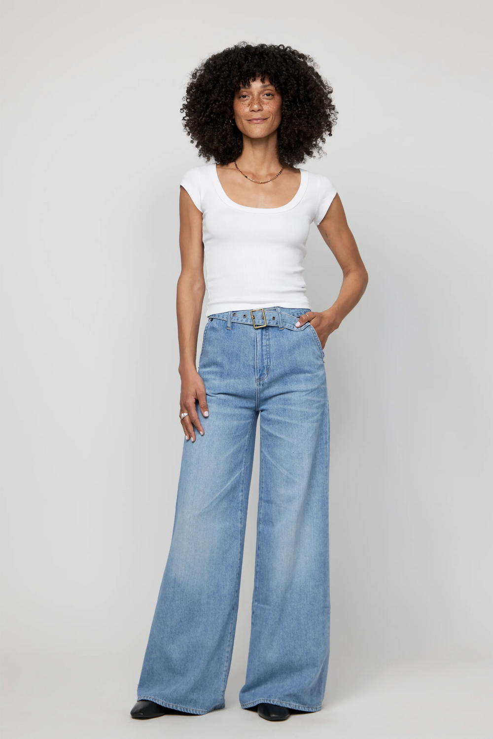 Woman wearing high-rise wide-leg jeans with a fitted white tank, styled for a casual everyday look.