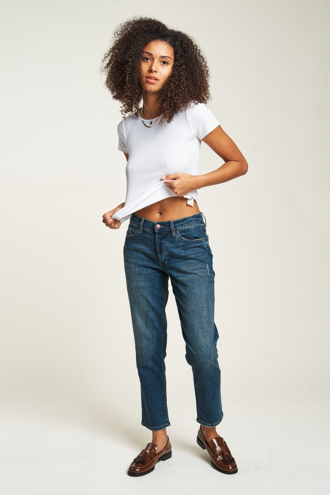 Front view of a model wearing relaxed fit straight leg jeans in a mid-rise style. The vintage jeans women design offers a timeless, laid-back look.