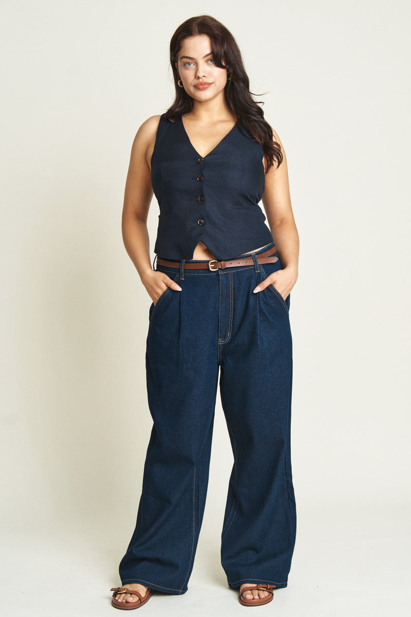 Curvy model facing front in dark blue low-slung baggy jeans, styled with a fitted gray t-shirt, highlighting a relaxed and effortless vibe.
