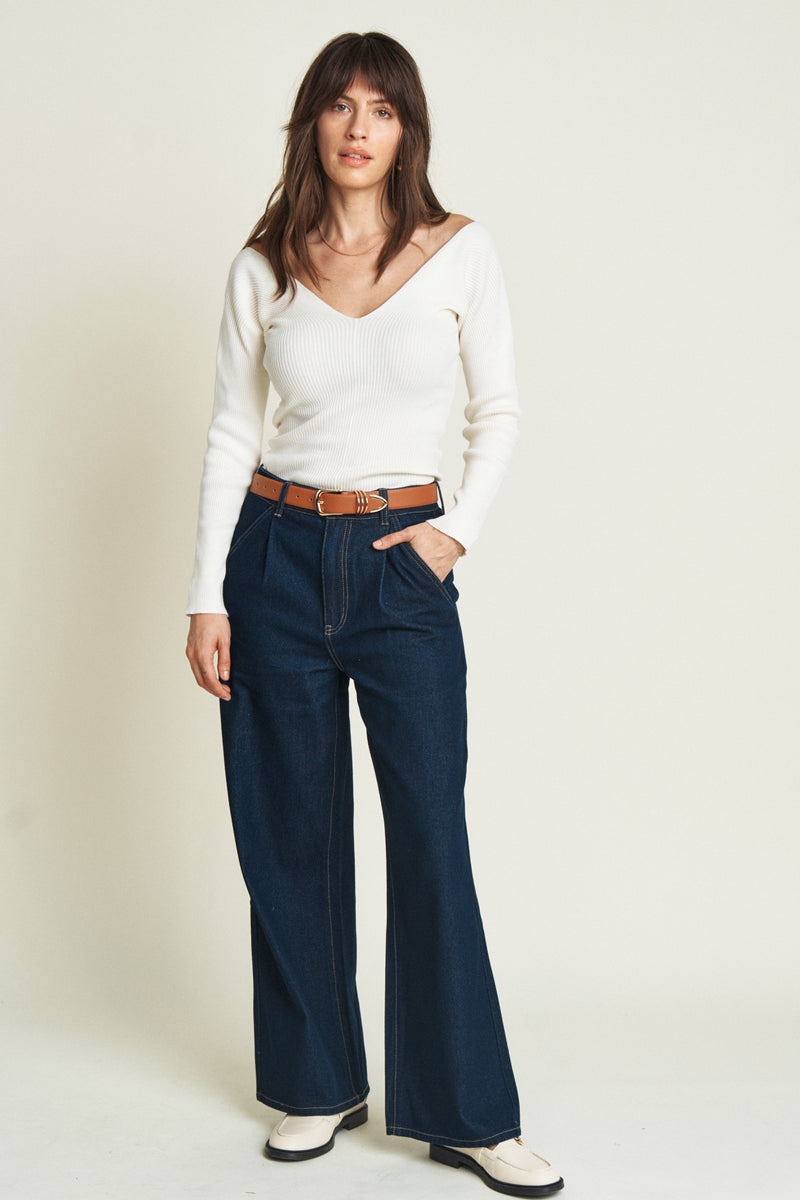 Model facing front in dark blue low-slung baggy jeans, paired with a fitted gray t-shirt, highlighting their relaxed fit and timeless design.
