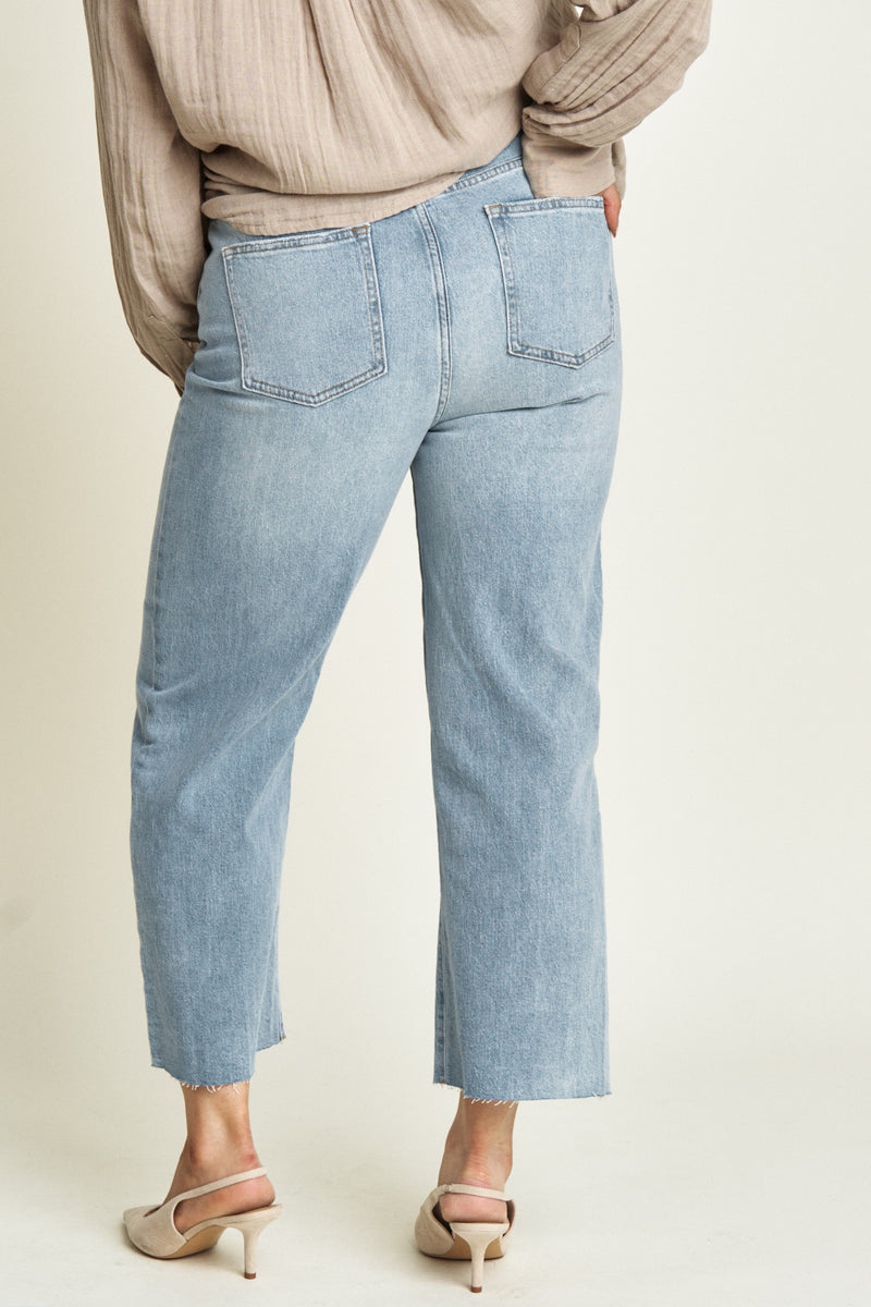 Back view of high-rise straight fit ankle crop jeans in durable denim, showcasing structured pockets, a flattering silhouette, and timeless deep blue wash.