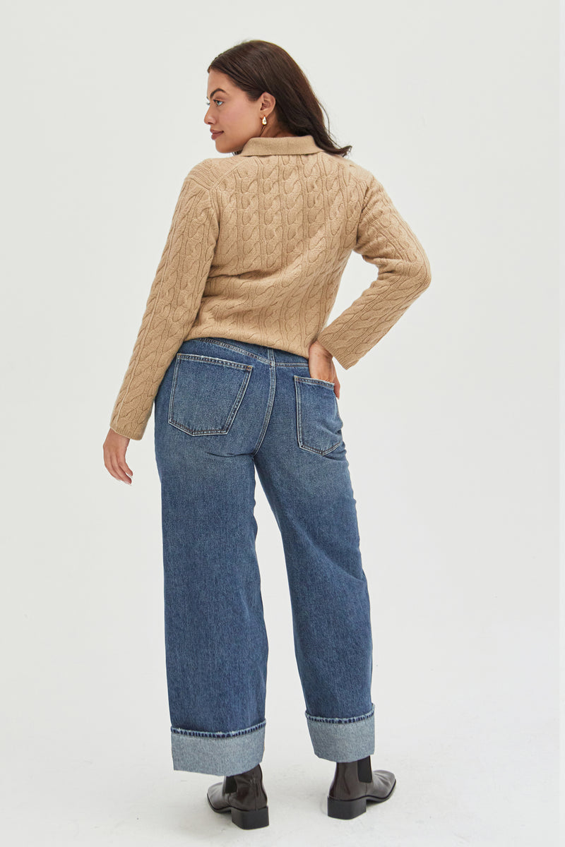 Back view of mid-rise wide-leg jeans in durable denim, showcasing structured pockets, a relaxed silhouette, and a folded cuff detail for a modern touch.