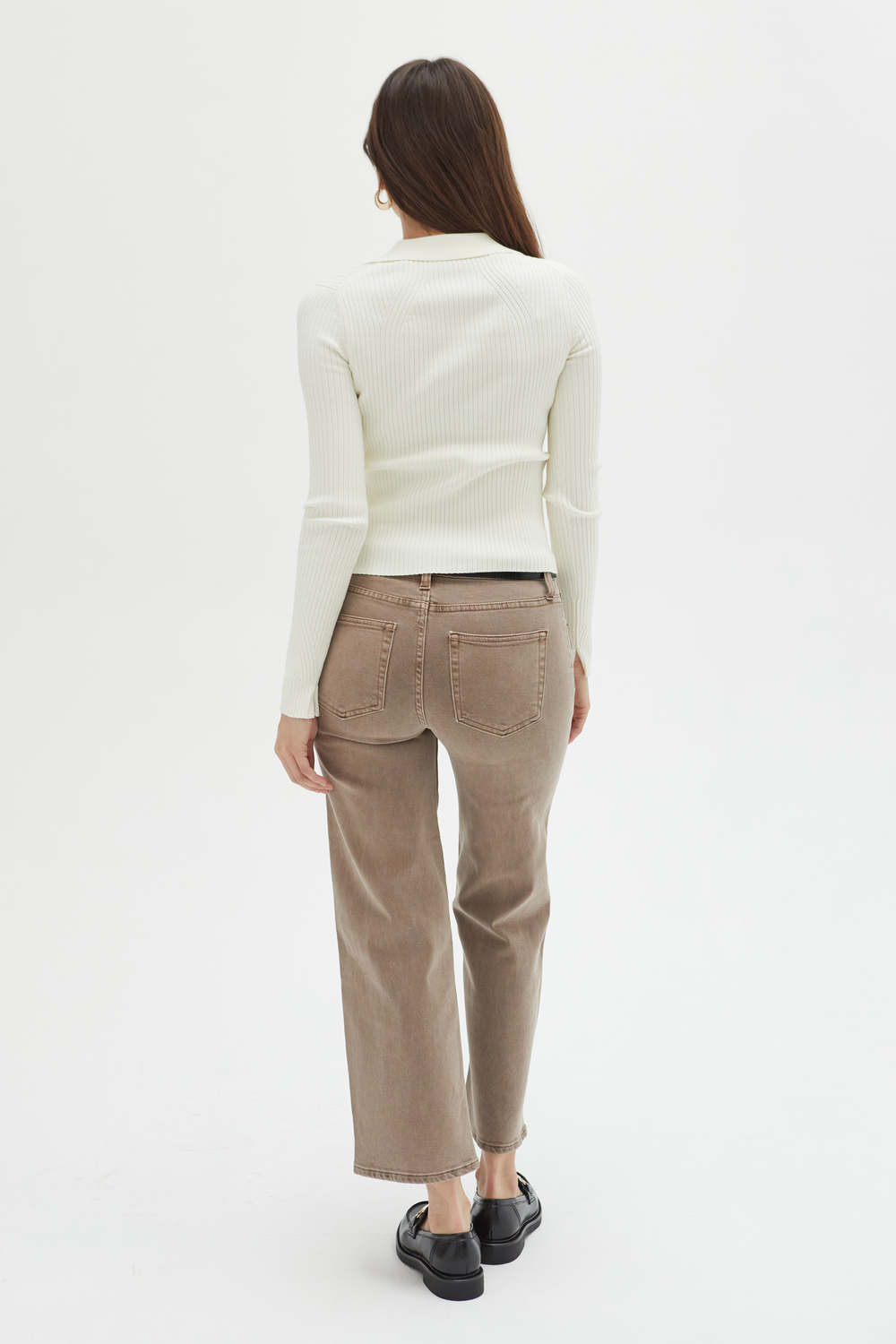 Back view of a model in brown wide-leg ankle crop jeans, highlighting the structured silhouette and clean design.