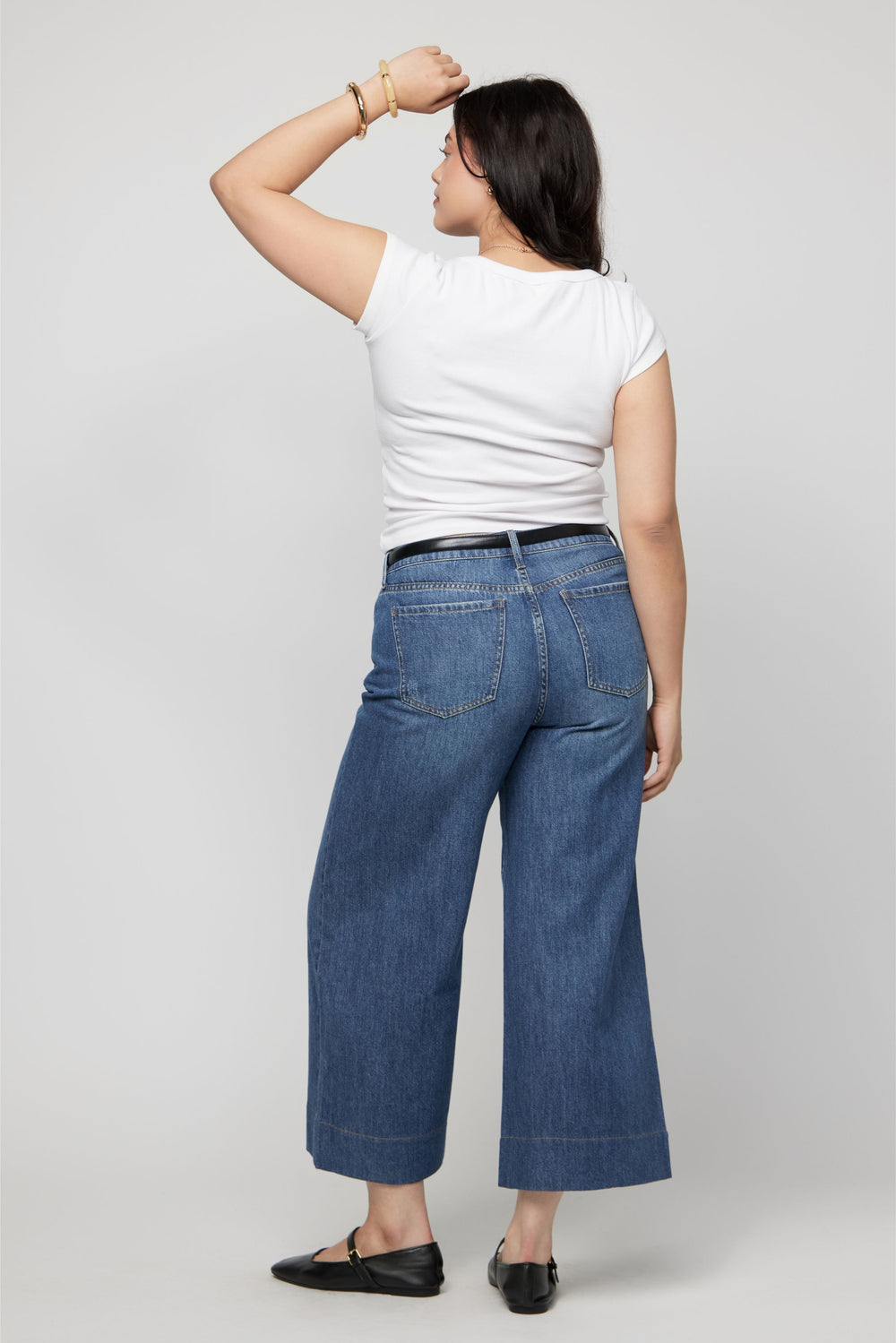 Side view of wide-leg high-rise cropped denim pants for women styled casually with sandals.