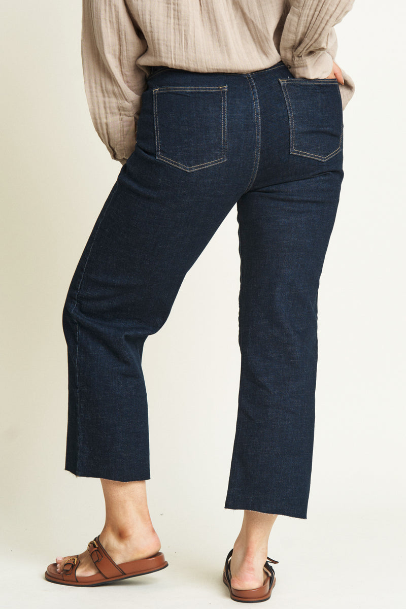 Back view of plus-size model in high-rise dark-washed denim jeans.