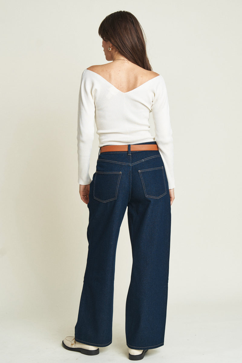 Back view of model in low-rise, relaxed-fit baggy jeans, showcasing the deep blue wash and casual, loose silhouette.
