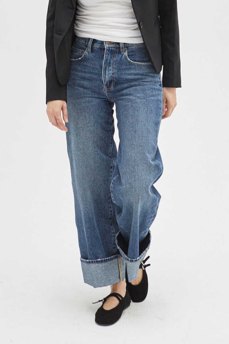 Close-up of mid-rise wide-leg jeans, highlighting the structured waistband, cuffed detail, and soft denim fabric for a timeless, relaxed fit.