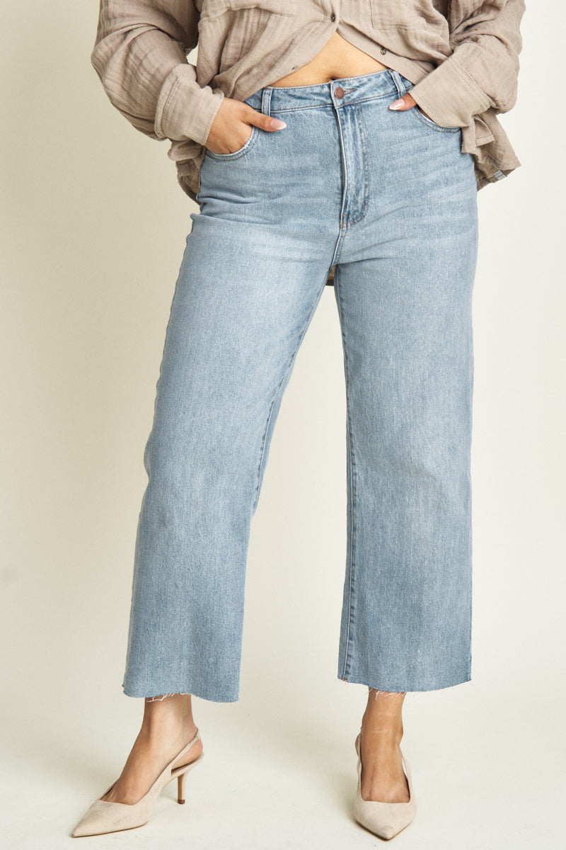 Close-up of high-rise cropped denim jeans for women, highlighting the waistband, sleek stitching, and ankle-length cut for a modern, minimalist aesthetic.