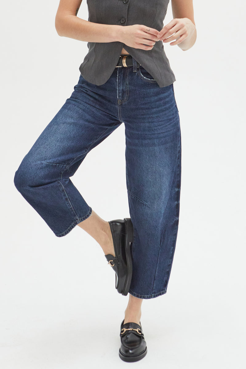 Close-up of high-rise barrel jeans, emphasizing the curved leg detail and durable, sustainable denim material.