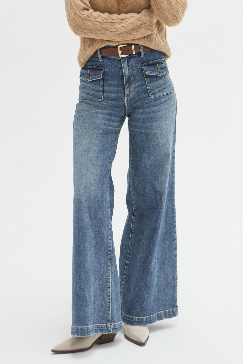 Close-up of medium blue high-rise wide-leg jeans, emphasizing the durable denim fabric and flattering high-rise waistline.