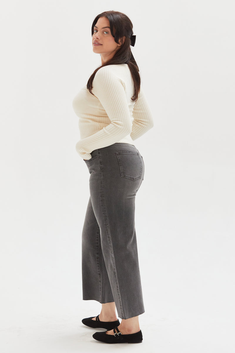 Side view of a model in relaxed-fit cropped wide-leg jeans, showing the flowy silhouette and timeless design.