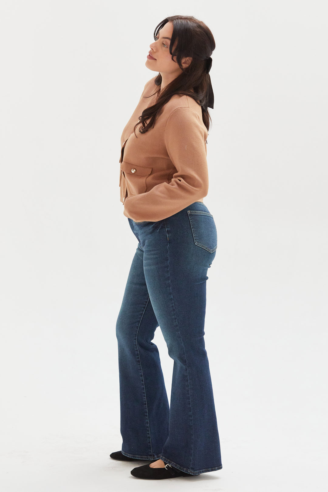 Side view of a plus-size model in olive wide-leg ankle crop jeans, styled casually with a neutral top, showcasing their modern and versatile design.
