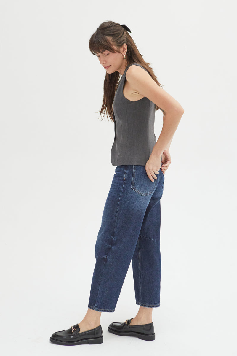 Side view of a model in barrel jeans, styled casually with a tucked tank top and loafers, showcasing their modern and versatile appeal.
