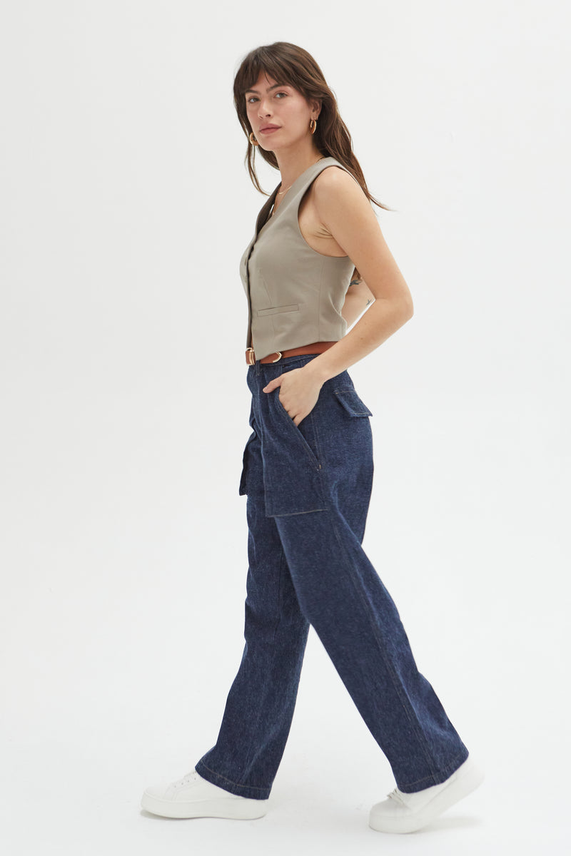 Side view of a model in trouser jeans, paired with a brown belt and beige tank, showcasing their versatility and modern style.