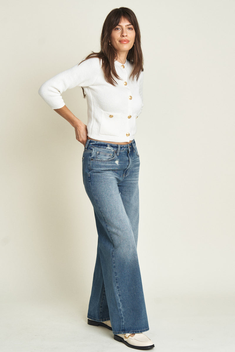 Side view of a model in mid-rise wide-leg jeans, paired with a classic white top, showcasing their versatile and timeless appeal.