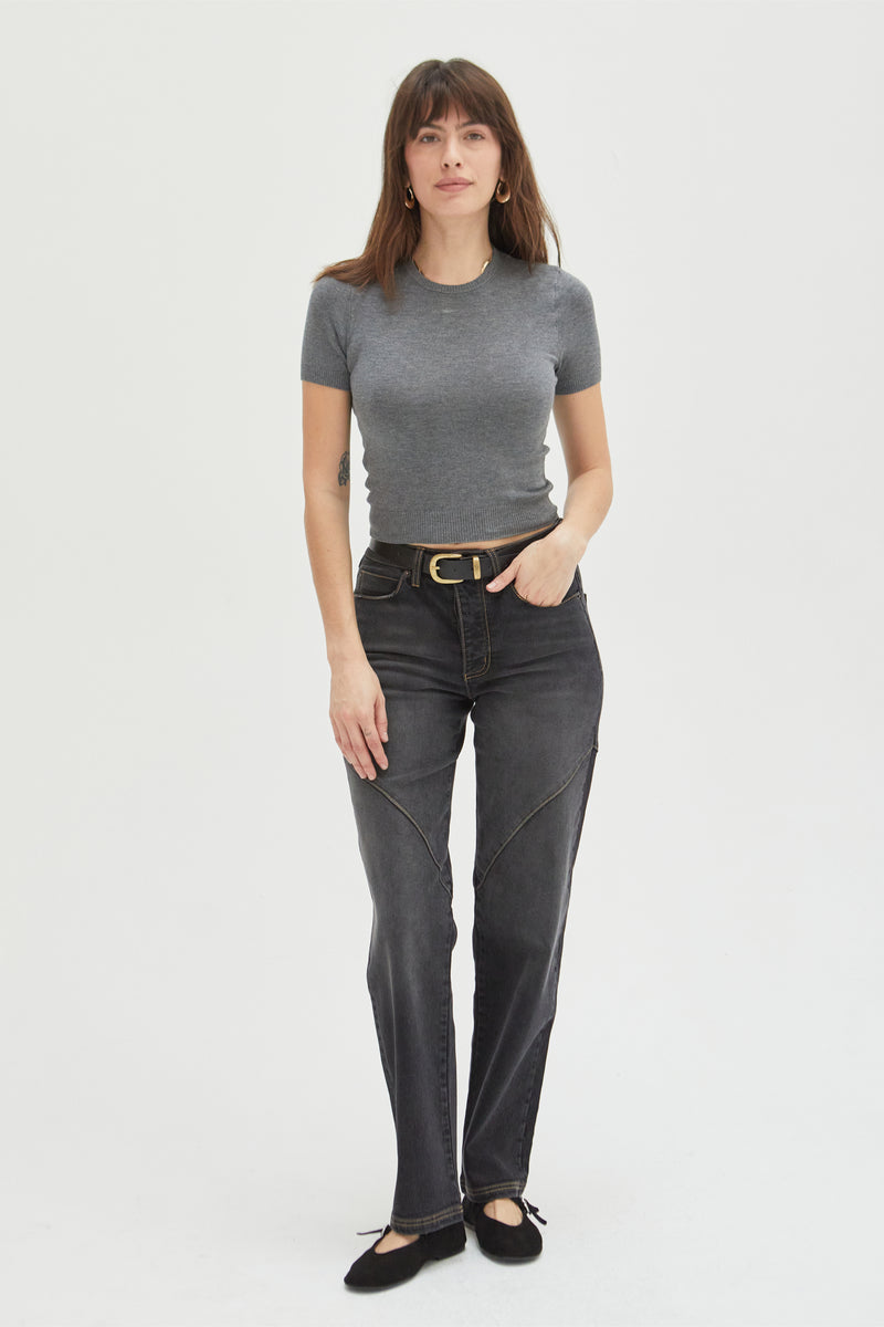 Model wearing high-rise straight leg jeans in a dark wash, paired with a gray fitted top, showcasing a structured yet relaxed fit.