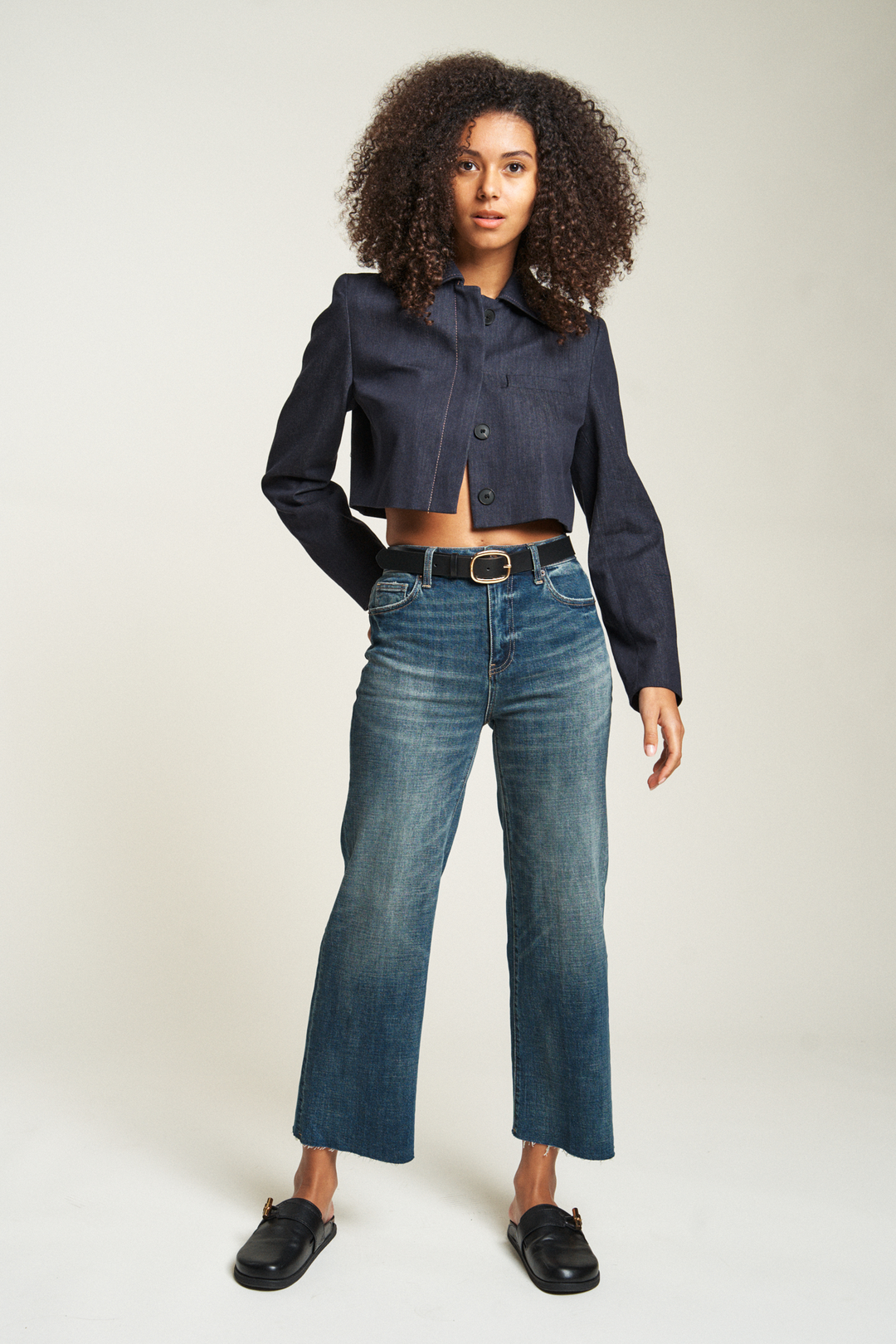 Front view of model cropped from the waist down showing the fit of high-rise cropped dark blue jeans