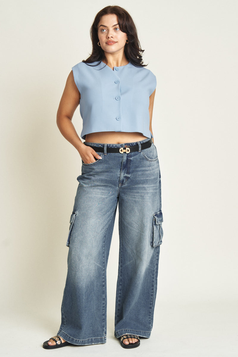 Video of plus-size model walking forward in sustainable wide-leg cargo jeans, darker blue washed denim with practical pocket details.