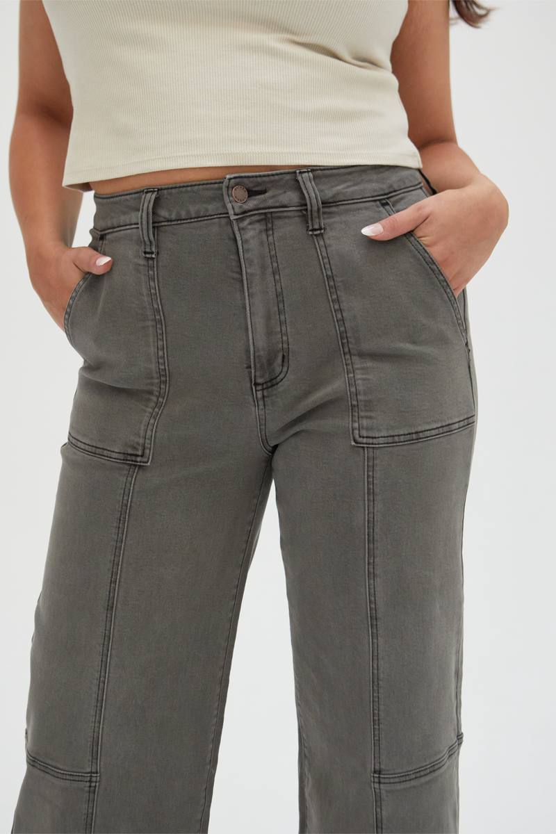 Plus-size model moving in olive wide-leg ankle crop jeans, demonstrating their flexibility and all-day comfort.