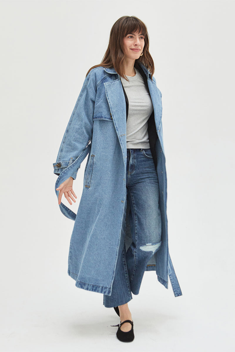 Model moving in a light wash denim trench coat, demonstrating its relaxed fit and everyday wearability.