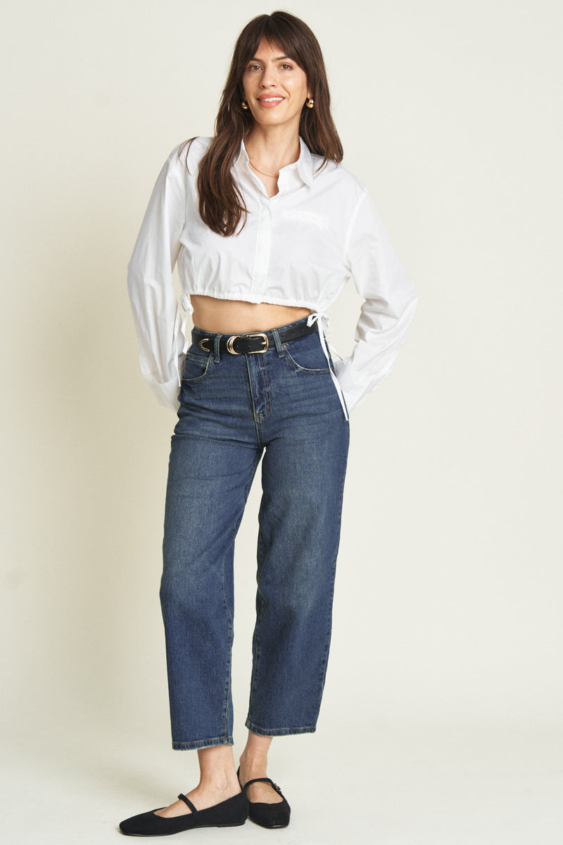 Model confidently wearing curved leg barrel jeans, styled with a white blouse, showcasing the relaxed silhouette.