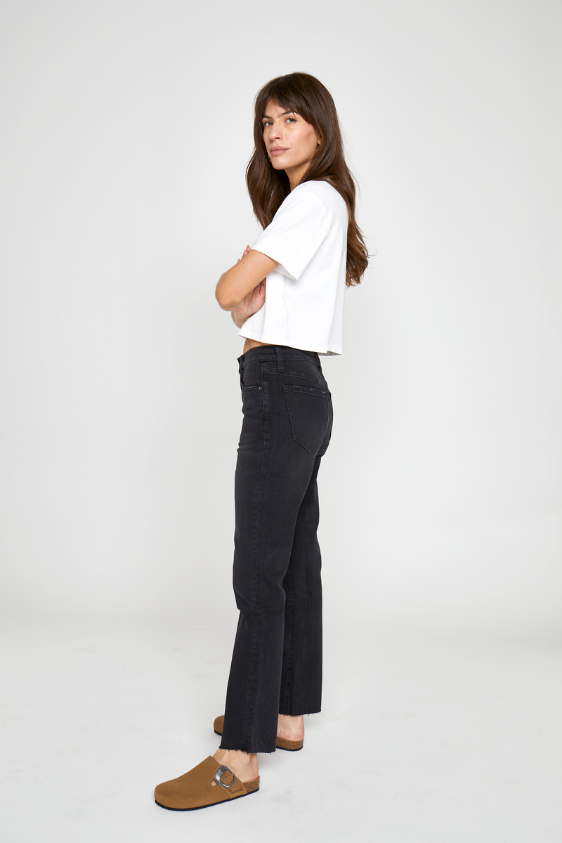 Side view of a model in high-rise tapered-leg jeans, paired with a casual cropped top, showcasing their versatile and stylish appeal.
